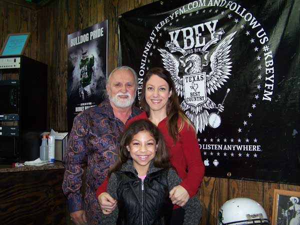 KBEY 103.9 FM guests Randy Hilmer (left) and Laura Gisi (right) of the Hill Country Community Theatre and Riley Gisi.