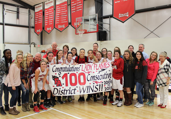 Players current and former, coaches and fans celebrate 100 straight district wins for the Faith Academy Lady Flames basketball team.