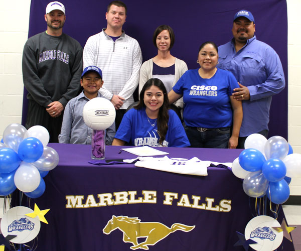 Marble Falls High School senior Natalie Chapa (seated) signs her letter of intent to play volleyball at Cisco Junior College surrounded by her brother Logan (front row, left), Marble Falls athletic director Matt Green (back row, left), Marble Falls girls coordinator David Schubert, Marble Falls head volleyball coach Casey Schubert and parents Laura and Ronnie Chapa. Staff photo by Jennifer Fierro
