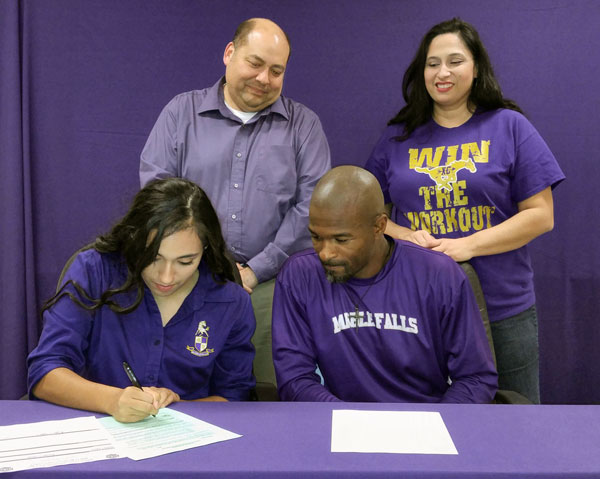 Marble Falls High School senior runner Nydia Castro (seated, left) signs her letter of intent to run for Ranger College on March 11 as Mustangs head cross-country and girls track coach Anthony Torns (seated) and parents, Javier and Gabriela Castro, look on. Staff photo by Jennifer Fierro