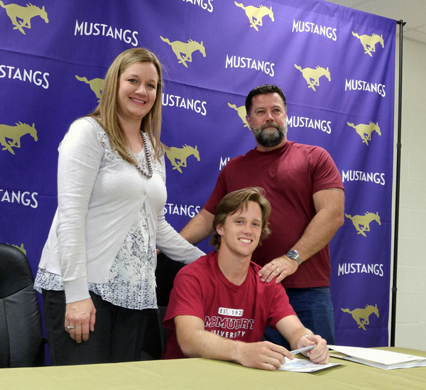 Marble Falls High School senior receiver Jacob Metcalf (seated) signs his letter of intent to play football and run track for McMurry University on April 8 as parents Juley and Todd Metcalf look on. Staff photo by Jennifer Fierro