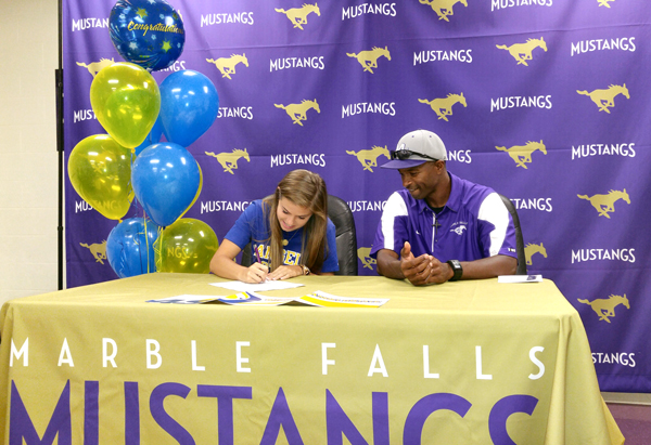 Marble Falls High School senior Natalie Schulz signs her letter of intent May 11 to be a member of the Angelo State University track-and-field team as Lady Mustangs head coach Anthony Torns watches. ASU, located in San Angelo, is a member of the Lone Star Conference in the NCAA’s Division II. Staff photo by Jennifer Fierro