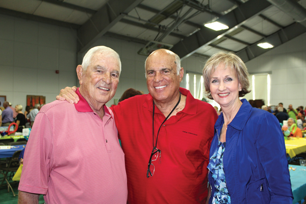 Former Texas Tech head football coach Spike Dykes accepts a hug from his granddaughter, Charli, the daughter of University of California-Berkley head football coach Sonny Dykes at the Emory Bellard-Spike Dykes Seton Kids Care-A-Van Tailgate Party on June 17. Staff photo by Jennifer Fierro