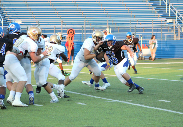 Llano High School graduate Colton Center blocks his former Yellow Jackets teammate Wyatt Baumann (35). After the play ended, Center helped Baumann to his feet, and the two exchanged hand slaps.