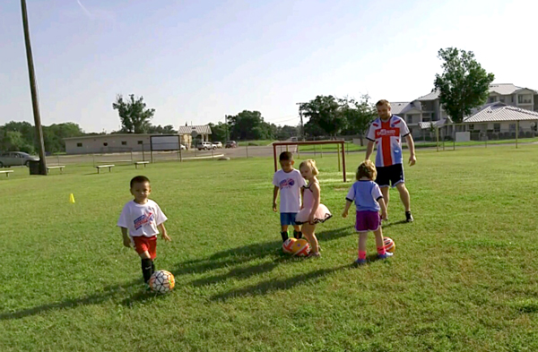 Young soccer players learn dribbling skills during a camp conducted by counselor James Pritchard of ChallengerSports.com on ‘The Greens’ soccer fields, located on Avenue K in Marble Falls. Youth sports leaders want the city to improve The Greens’ facilities and add more fields as part of the update to the Park, Recreation and Open Space Master Plan. Staff photo by Jennifer Fierro