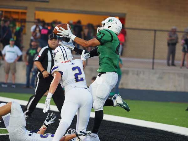 Burnet’s Steven Gallardo finds enough space to snatch a touchdown pass between to Mustang defenders in the Bulldog’s 33-12 win over Marble Falls on Sept. 2. Photo by Glenn Morris/ftog.com