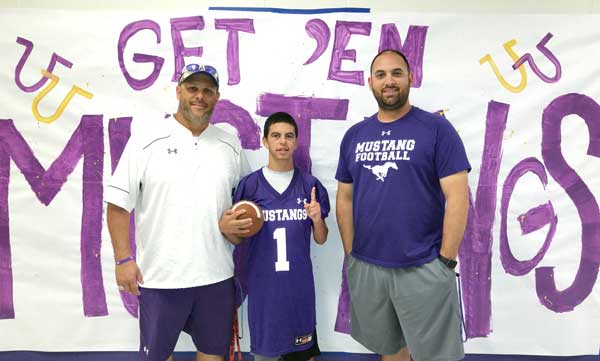 Marble Falls Middle School student J.J. Tellez holds the football the way he was taught by Marble Falls Middle School boys athletic coordinator Jamie Graham (left) and coach Corey Kenyon. Staff photo by Jennifer Fierro