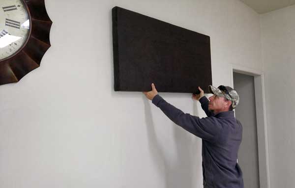 City of Marble Falls parks technician Brian Murphy places a soundboard on a wall in the Westside Park Community Center. Staff photo by Jennifer Fierro
