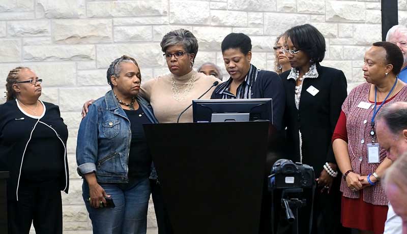 People gather around Reneé Semien as she shares her concerns regarding PEC District 5 director and board vice president James Oakley and his Facebook post of ‘Time for a tree and a rope’ in reference to the arrest of an African-American man in connection to the murder of a San Antonio police officer. Staff photo by Daniel Clifton