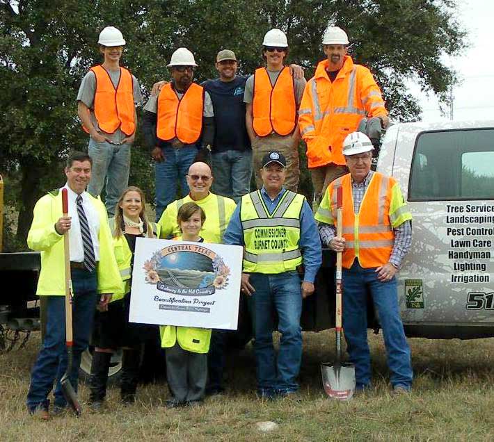 Volunteers with the cooperation of private business and state and county officials have launched a community gateway project at the intersection of Texas 71 and U.S. 281 to introduce motorists to the Marble Falls area. Pictured are (back row from left) Mills Services crew members Lane Webb, Paulino Espinosa, Bradlee Mills, Dylan Linderman, and Curtis Cunningham; (middle row from left) Burnet County Sheriff Calvin Boyd, volunteer Shannon Heep, organizer Soc Gonzalez, Burnet County Commissioner Joe Don Dockery, and Texas Department of Transportation maintenance supervisor Stephen Schmidt; and volunteer Isaac Pittenger (holding sign). Courtesy photo