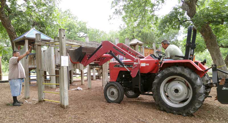 Tony Nandin Jr. (left) uses a hammer to remove one of the bars on the wooden playscape in Johnson Park as his dad, Tony Sr., watches. Staff photo by Jennifer Fierro
