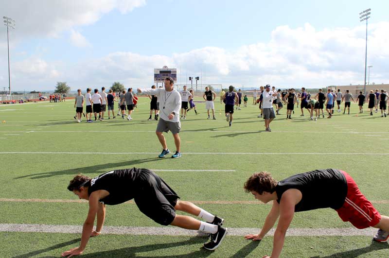 Marble Falls High School interim head football coach and athletics director Michael Birdwell puts the Mustangs through mat drills on the first day of voluntary strength-and-conditioning workouts June 12 at Mustang Stadium. Staff photo by Jennifer Fierro