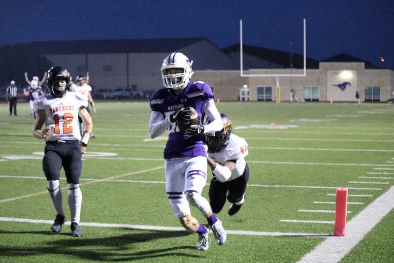 Marble Falls senior receiver Keegan Deering scores the first touchdown of the game against Castroville Medina Valley on Sept. 29 on a 30-yard pass from junior quarterback Andrew Stripling. The Mustangs lost 50-30. Photo by Luedecke Photography