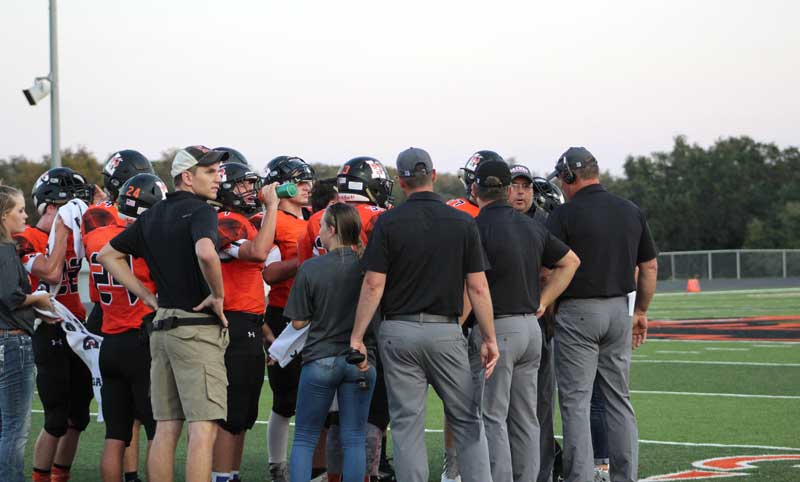 Llano High School defensive coordinator Clint Easley (right) talks to defensive line coach Ricky Sparks (wearing the headset) during a timeout. Staff photo by Jennifer Fierro