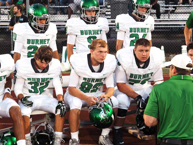 Burnet High School junior outside linebacker Dylan Wilson (sitting, left), junior defensive lineman Alan McMeans, and senior defensive lineman Seth Carpenter; and junior linebackers Gerardo Murillo (standing, left) and Silver Hinson and senior linebacker Braden Jannamon listen to instructions during the Bulldogs’s 27-14 win against Marble Falls on Sept. 8. The Bulldogs defense faces a two-quarterback threat as Burnet hosts Fredericksburg on Sept. 15. Staff photo by Daniel Clifton