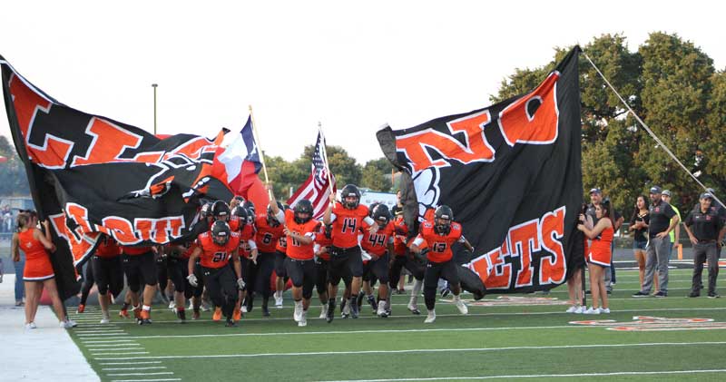 The Llano High School football team runs onto the field before a recent game. Staff photo by Jennifer Fierro