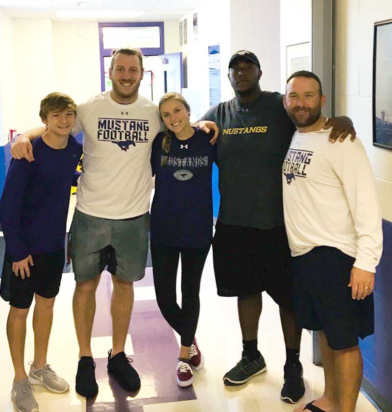 While in the area last week, Minnesota Vikings tight end David Morgan (second from left) and his girlfriend Langlie Cooley stopped by the Marble Falls High School fieldhouse to pick up some Mustangs gear from junior varsity player Jett Huffman (left), defensive line coach Cyril Lemon, who was a high school teammate of Morgan’s and the two graduated in 2011, and Marble Falls interim head coach Mike Birdwell. Courtesy photo
