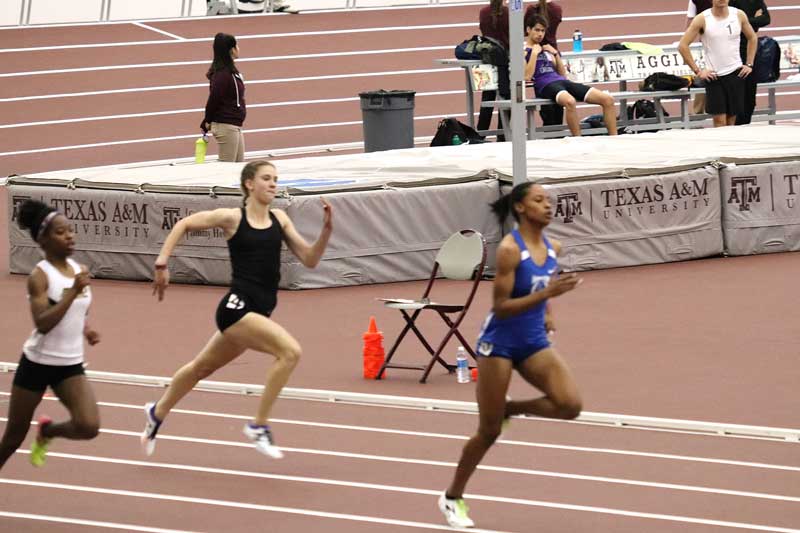 Marble Falls High School freshman runner Bailey Goggans (in black uniform) competed Jan. 6 at the Texas A&M University Indoor Meet, where she ran the 400 meters in 56.99 seconds. Leading the race is Frisco Heritage runner Bailey Lear, the state’s top 400-meter runner. Photo courtesy of Goggans family