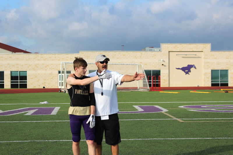 Marble Falls High School offensive coordinator and quarterbacks coach Kerry Graham tells rising junior receiver Hayden Wells which route he is expected to run during a specific play. Staff photo by Jennifer Fierro