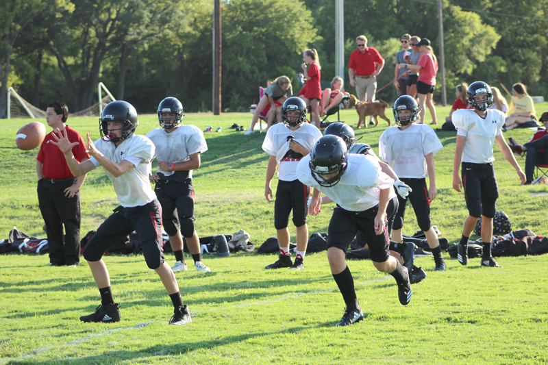 Faith Academy of Marble Falls freshman quarterback Kooper Cain took the shotgun snap as freshman running back Justin Mottle sprinted to the flat during a scrimmage against Giddings State School on Aug. 17. Staff photo by Jennifer Fierro