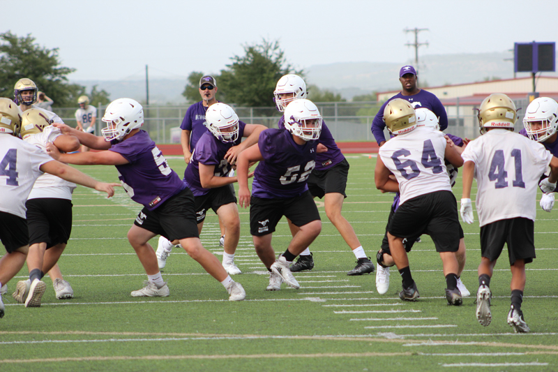 Marble Falls senior running back Dylan Mayberry takes a handoff from senior quarterback Andrew Stripling and looks for a hole in the middle of the line. The Mustangs held their first day of fall football practice Aug. 13. Staff photo by Jennifer Fierro