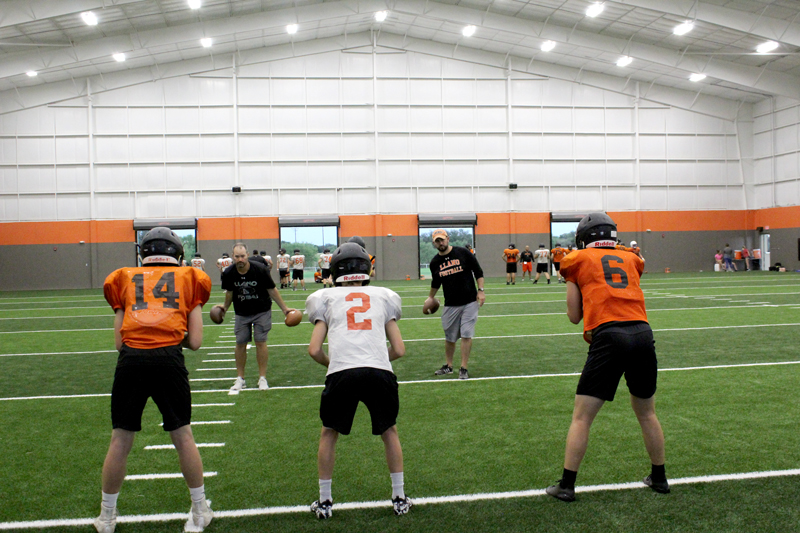 Llano quarterbacks Braxton Bickers (left), Luke Keller, and Cade Fly catch balls tossed to them from coaches as the skill players work on pass patterns during the Aug. 10 morning practice. Staff photo by Jennifer Fierro