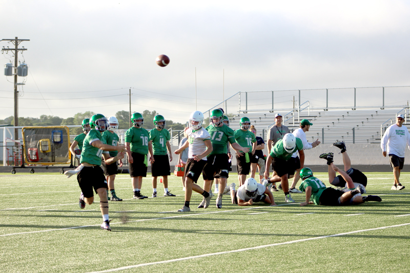 Burnet sophomore quarterback Jaxon Denton (left) throws on the run during the first practice of fall training camp Aug. 6. Denton started as a safety last season. Staff photo by Jennifer Fierro