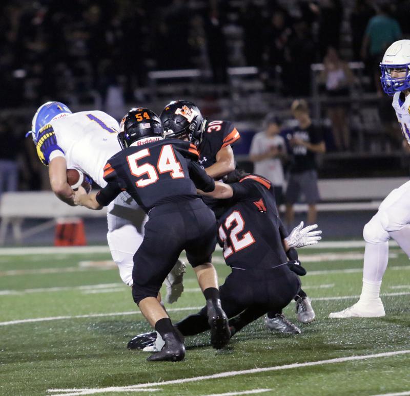 Llano junior linebacker Ryan Warner (54), sophomore safety Case Kuykendall, and senior defensive back Presley Lynch tackled Lago Vista sophomore running back Layne Powers during the Yellow Jackets’ 38-7 win Sept. 21. Courtesy photo