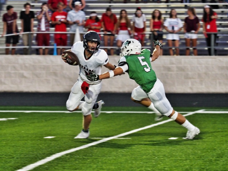 Burnet’s Silver Hinson pressures Wimberley’s Cooper McCollum during the 2018 season opener Aug. 31 at Bulldog Field. The Texans staged a late game-winning drive for a 31-25 victory. Staff photo by Daniel Clifton