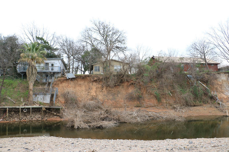 From Johnson Park in Marble Falls you can see the back of two properties on Buena Vista Drive that soon will be demolished. The Marble Falls Economic Development Corp. awarded a low bid of $37,250 to Hansco Inc. to demolish the homes at 108 and 112 Buena Vista Drive during its regular board meeting Feb. 6. The two EDC-owned properties are on the left and right of the photo. The middle building is privately owned. Staff photo by Jared Fields