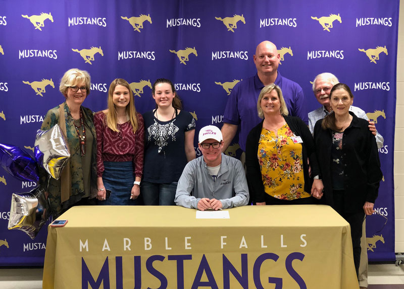 Marble Falls High School tennis player Mason Williams (seated) signs his national letter of intent to play for Arkansas’s University of the Ozarks, a NCAA Division III program, during a ceremony March 11. Courtesy photo