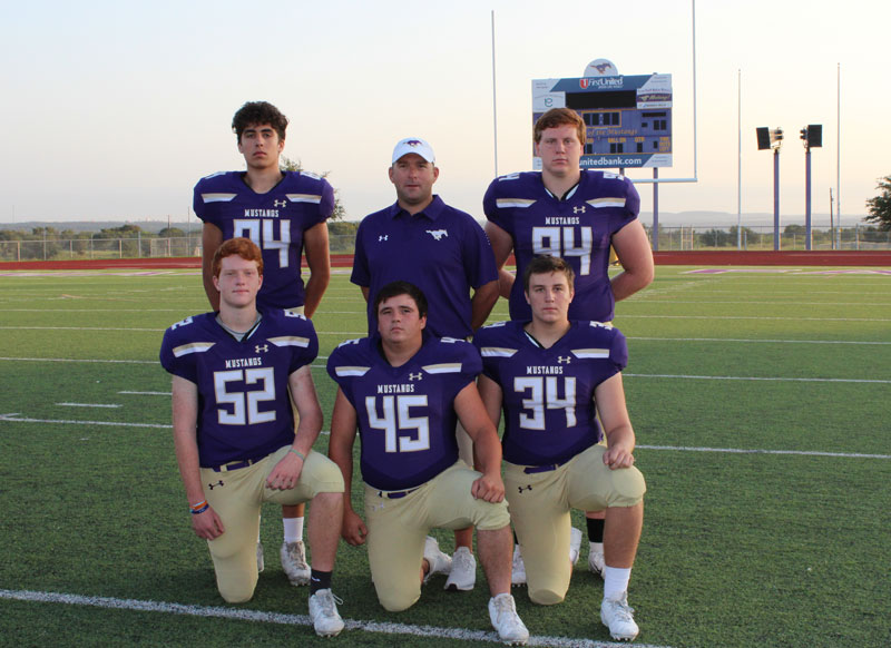 Marble Falls High School head football coach Mike Birdwell (standing, middle) announced his resignation March 11 via social media. He is pictured here with players Sam May (standing, left) and Josh Whitecotton and Elijah Todd (kneeling, left), Glenn Thomas, and Dillon Mayberry. Staff photo by Jennifer Fierro
