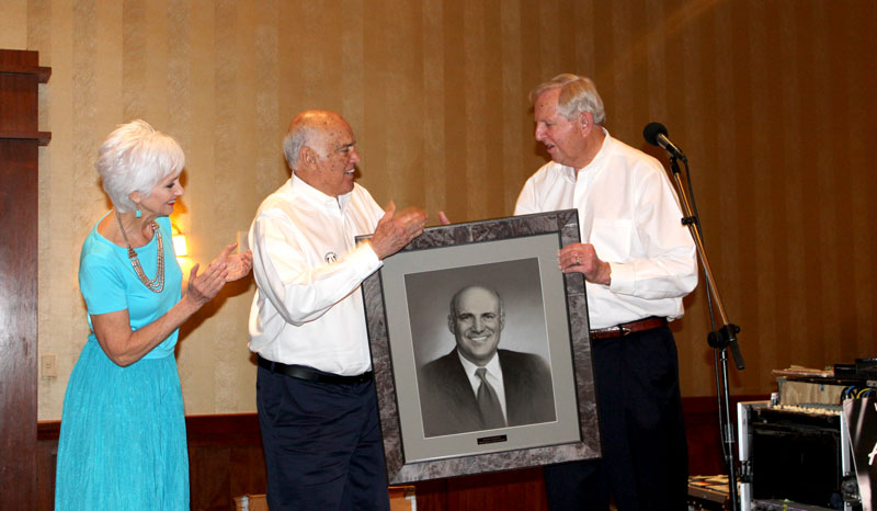 Steve Jordan (right), a board member of the newly renamed Rudy Davalos Horseshoe Bay Sports Club, presented a portrait of Davalos to the former athletic director and his wife, Gail, during the organization’s end-of-year banquet at Horseshoe Bay Resort on April 18. The club, once just called the Horseshoe Bay Sports Club, now includes Davalos’s name as he spearheaded its creation 10 years ago. Staff photo by Jennifer Fierro