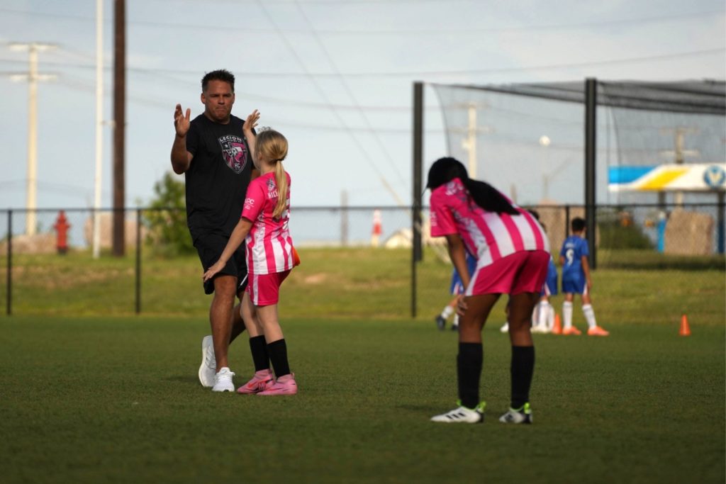 Coach James Turner high-fives Millie Rust 