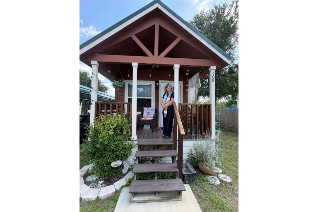 Terri Schexnayder on the porch of her tiny home in Kingsland
